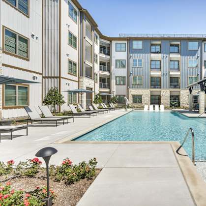 an outdoor swimming pool with an apartment building in the background