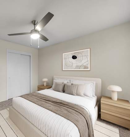A bedroom with a large bed and a ceiling fan.