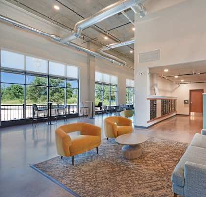 a living room with couches and chairs under a colorful ceiling