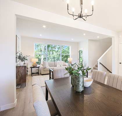 A modern dining room with a wooden table and chairs.