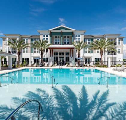 a swimming pool with palm trees in front of a building