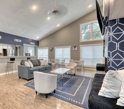 A modern living room with a grey sofa and a wooden floor.