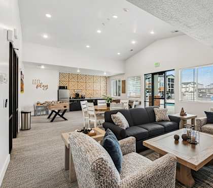 A spacious living room with a variety of seating options and a view of the outside.