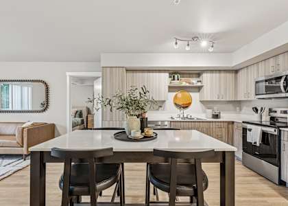 A modern kitchen with a dining table and chairs in the foreground.