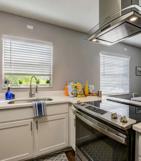 a kitchen with white cabinets and a stainless steel refrigerator