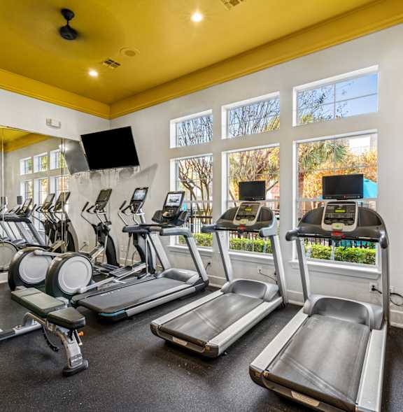 a gym with weights and other exercise equipment and windows