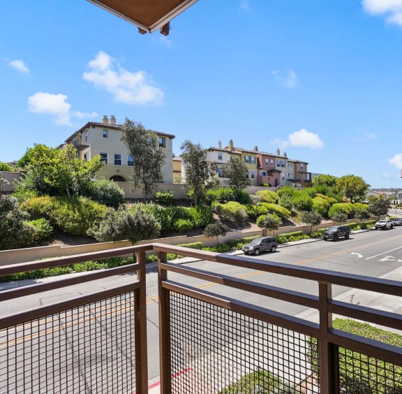 a view of the street from a balcony with a fence