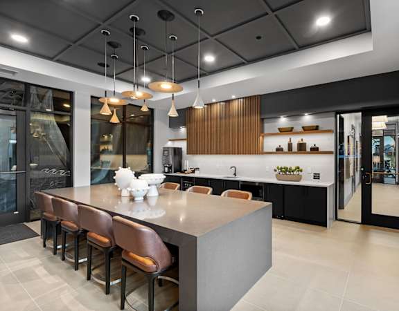 A modern kitchen with a long island and bar stools.