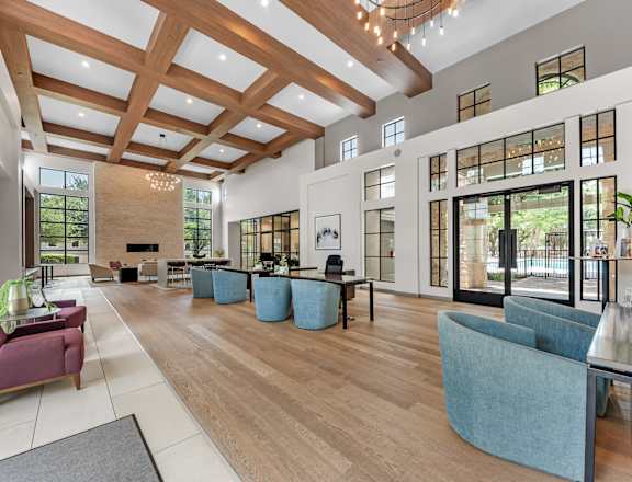 A spacious living room with a high ceiling and wooden beams.