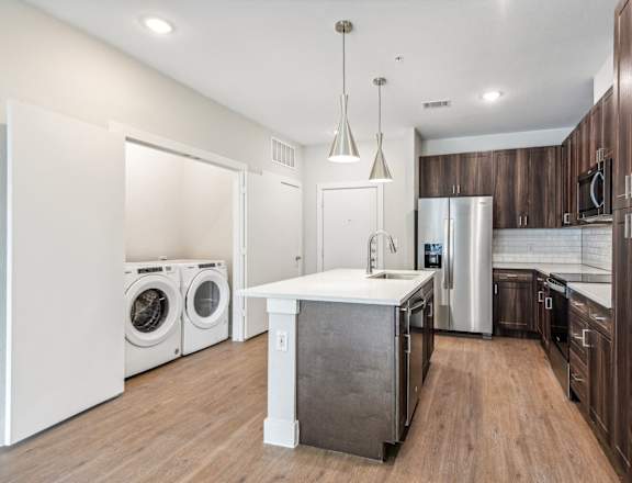a laundry room with a washer and dryer and a sink in a kitchen at The Virginia, Seguin, TX