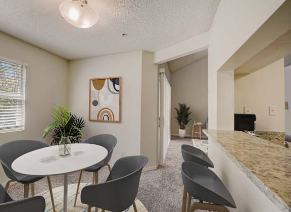A dining room with a round table and chairs.