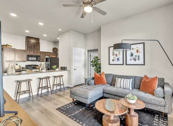 a living room with a couch and a kitchen with a bar