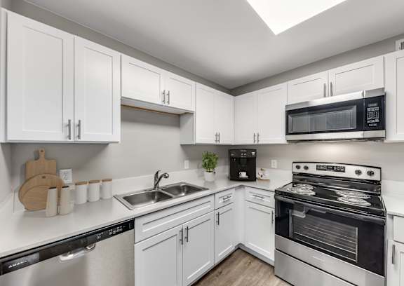 A kitchen with white cabinets and stainless steel appliances.