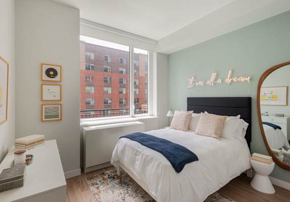 a bedroom with a bed and a large window