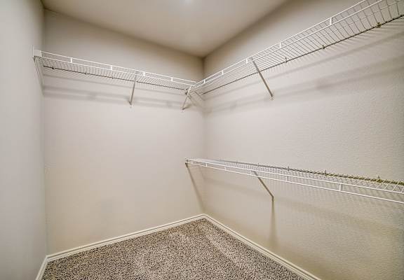 a spacious walk in closet with white walls