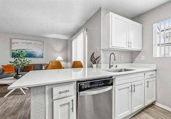 A modern kitchen with white cabinets and a stainless steel dishwasher.