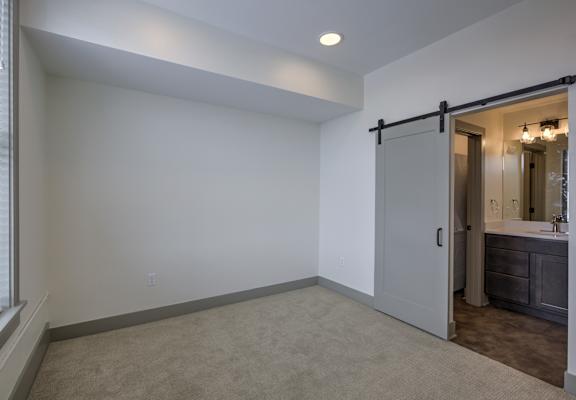 A room with a sliding door leading to a bathroom.