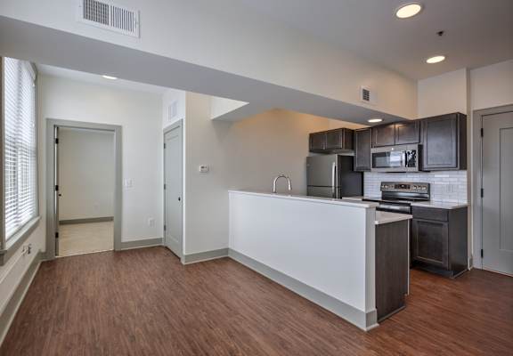 A kitchen with a white counter and stainless steel appliances.