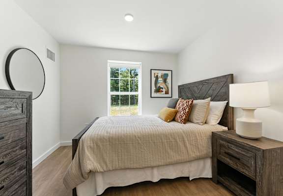 A bedroom with a large bed and a window.