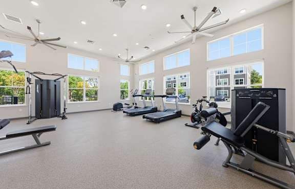 A spacious home gym with a variety of equipment including a treadmill, elliptical trainer, and a bench press.