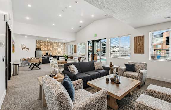 A spacious living room with a variety of seating options and a view of the outside.