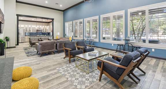 A spacious living room with a variety of seating options and a large window.
