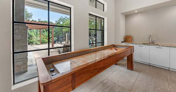 A modern kitchen with a wooden bench and a view of the backyard.