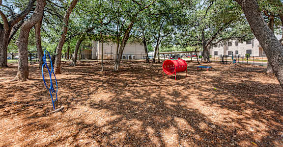 A dog park with a red barrel.