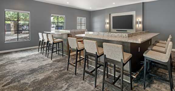 A modern dining room with a large table and chairs.