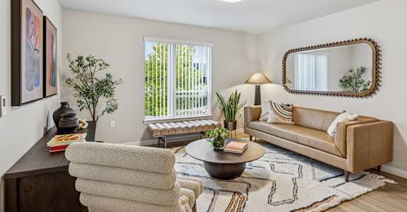 A well-lit living room with a couch, chair, and a coffee table.