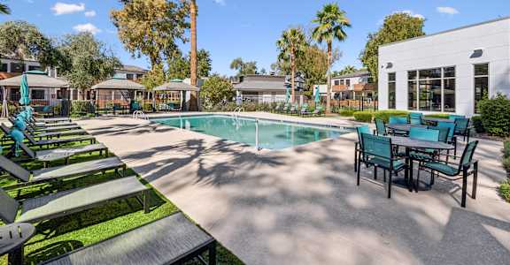 A pool area with sun loungers and a table.