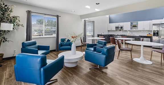 A living room with blue chairs and a white table.