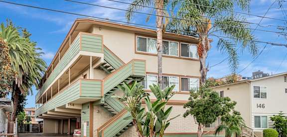 A two-story house with a green staircase on the side.