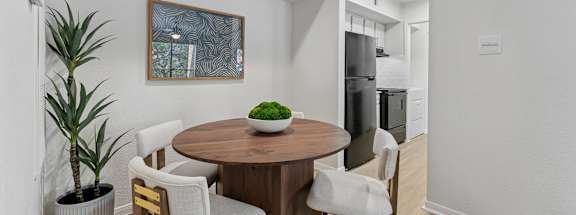 A dining room with a wooden table and chairs.