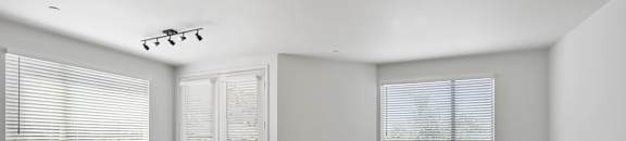 the living room of an empty house with wood floors and windows