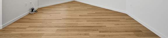 an empty room with white walls and wood floors