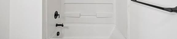 a white bathroom with a white tub and a white shower curtain