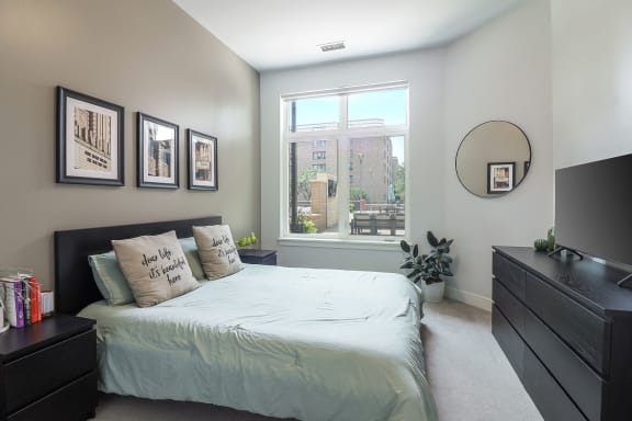 a bedroom with a bed and a large window