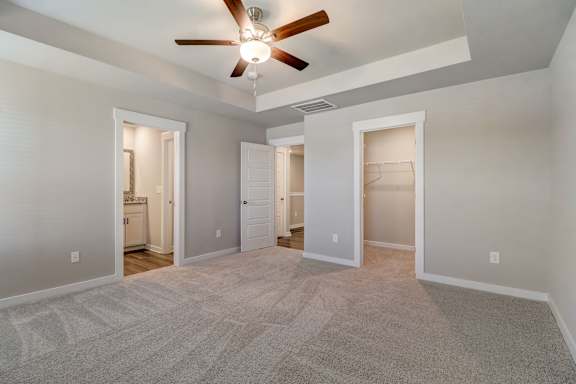 A spacious room with a ceiling fan and carpeted floor.