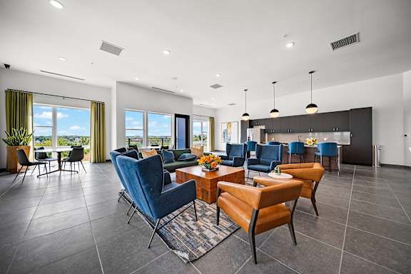 A modern living room with blue chairs and a dining table.
