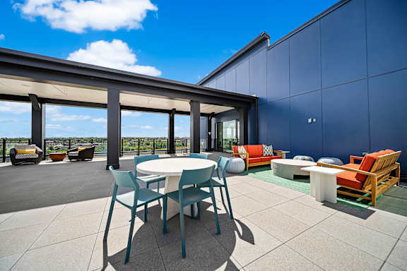 A patio with a table and chairs is set up on a rooftop.