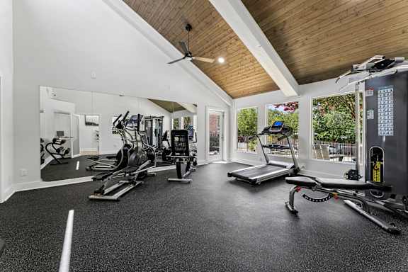 A spacious gym with a variety of equipment including treadmills, elliptical machines, and weights.
