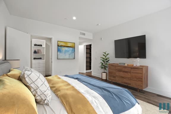 a bedroom with a large bed and a tv on the wall