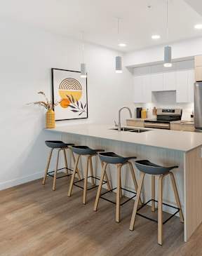 a kitchen with white cabinets and a large island with a breakfast bar