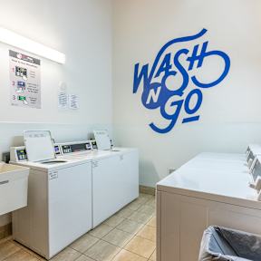 a laundry room with washing machines and a wash n go sign on the wall