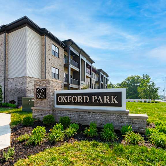 A sign that says Oxford Park in front of some buildings.
