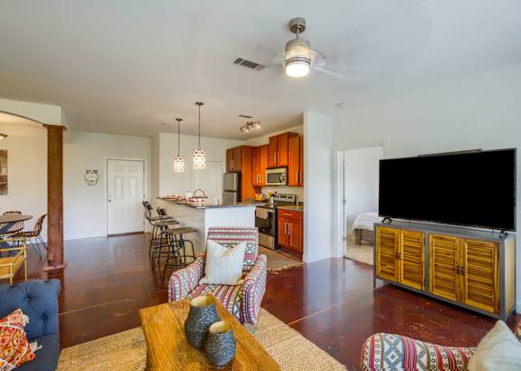 a living room filled with furniture and a ceiling fan