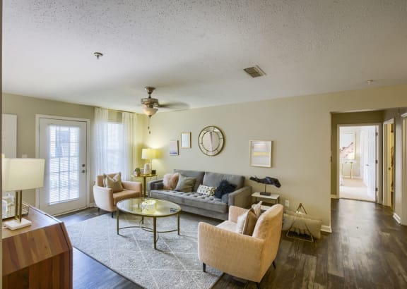 a living room filled with furniture and a ceiling fan