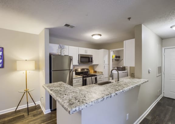 a kitchen with white cabinets and a granite counter top