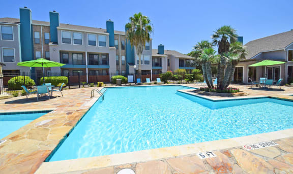 a swimming pool with an apartment building in the background